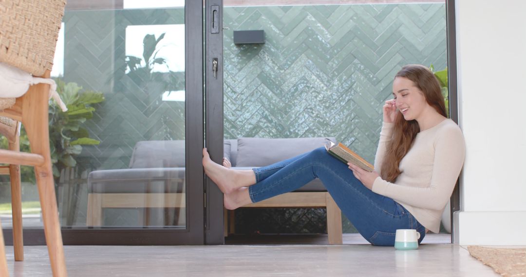 Woman Relaxing at Home Reading Book Near Patio Door - Free Images, Stock Photos and Pictures on Pikwizard.com