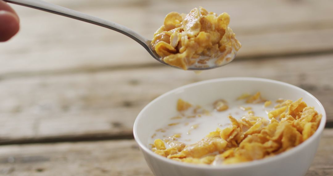 Bowl of Crunchy Cornflakes with Milk on Rustic Wooden Table