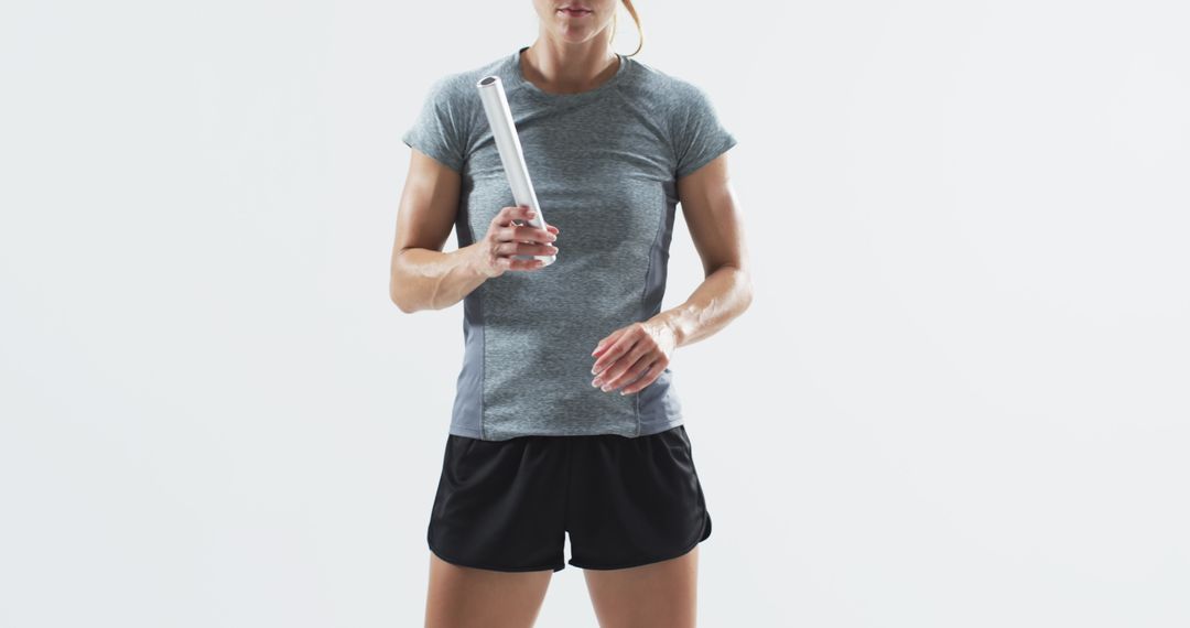 Athletic woman holding relay baton preparing for race