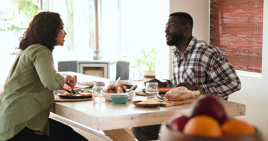 Couple Enjoying Meal Together at Home with Roast Chicken and Bread