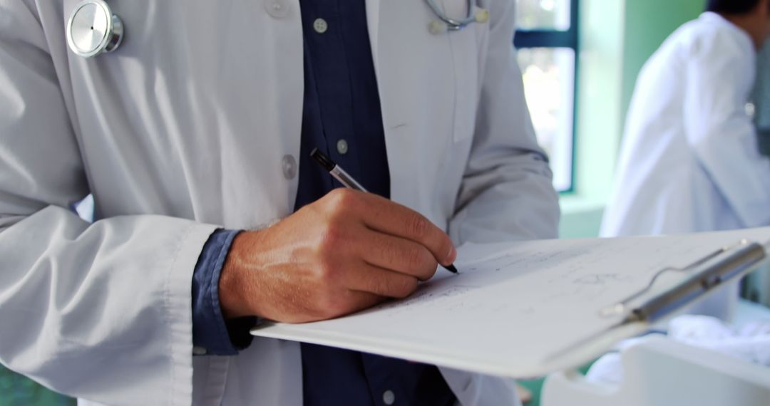 Caucasian Doctor Writing Notes in Hospital Ward - Free Images, Stock Photos and Pictures on Pikwizard.com