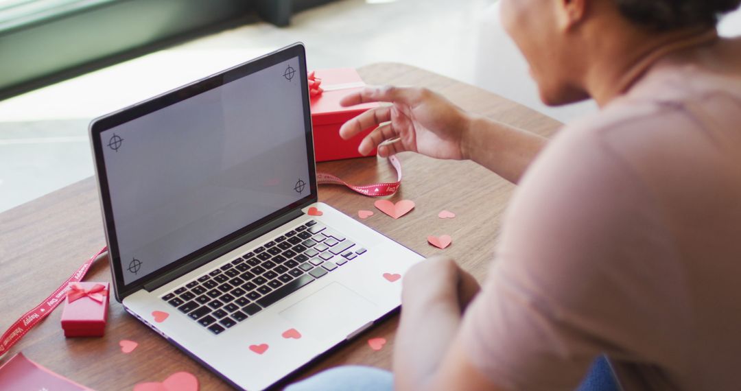 Man Engaging in Virtual Call with Gift and Heart Decor