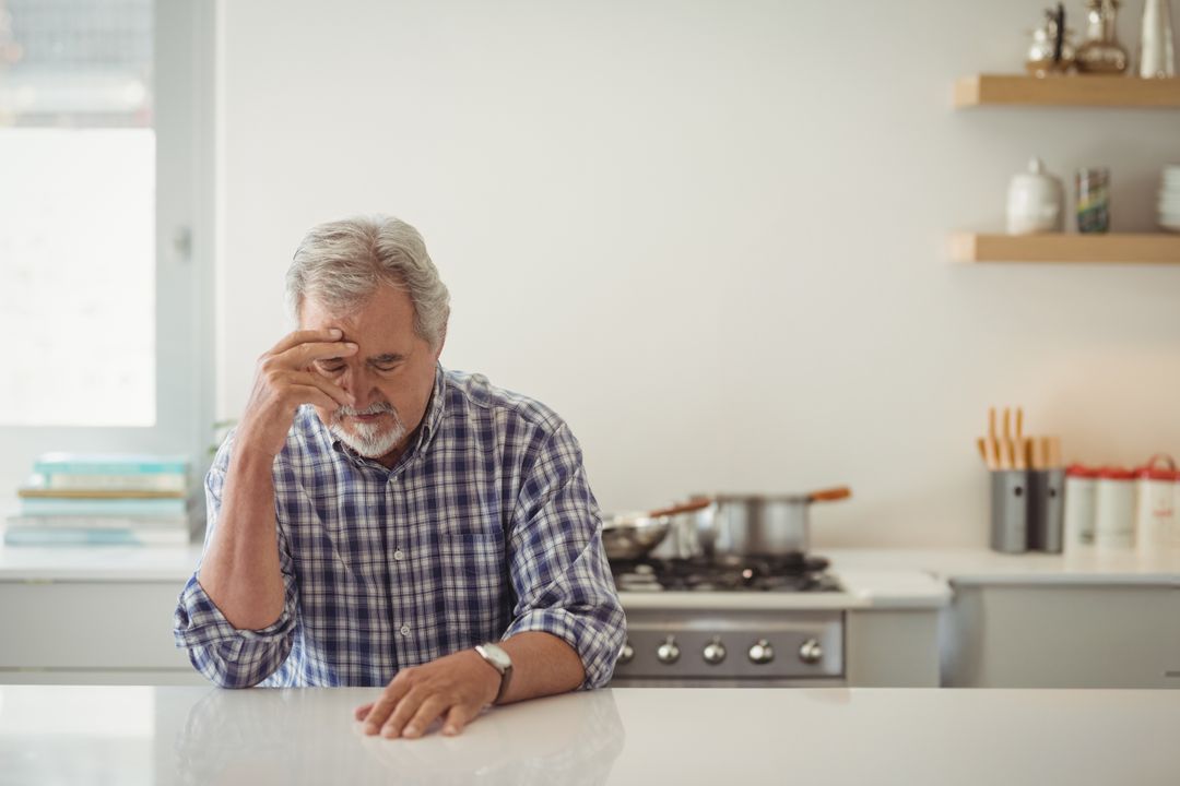 Elderly Man Contemplating in Modern Kitchen Environment