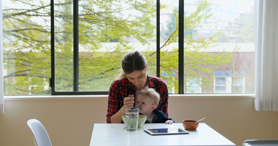 Mother Feeding Infant at Dining Table with Nature View - Free Images, Stock Photos and Pictures on Pikwizard.com