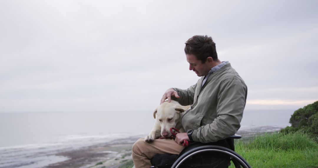 Man Sitting in Wheelchair Petting Dog by Ocean View - Free Images, Stock Photos and Pictures on Pikwizard.com