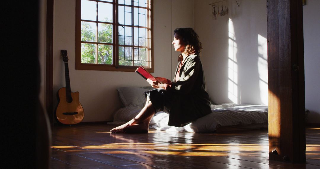 Young Woman Reading Book in Sunlit Room, Relaxation and Leisure at Home - Free Images, Stock Photos and Pictures on Pikwizard.com