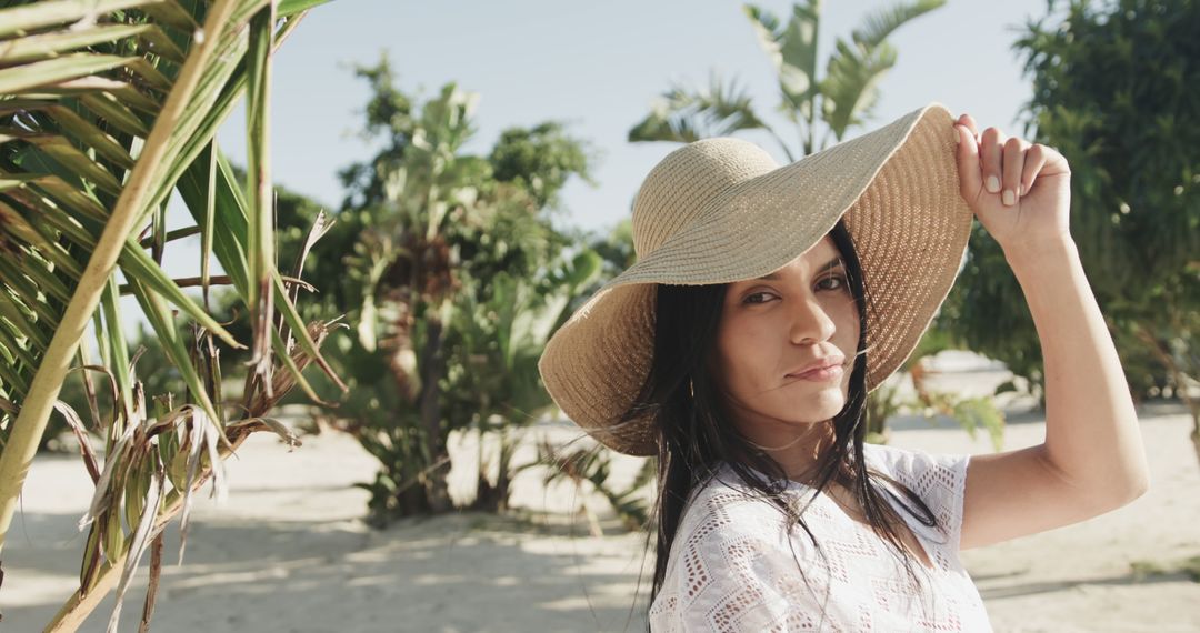 Woman in sun hat smiling on tropical beach on sunny day - Free Images, Stock Photos and Pictures on Pikwizard.com