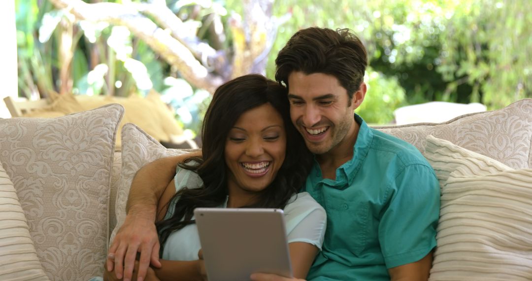 Smiling Couple Relaxing on Couch Using Digital Tablet - Free Images, Stock Photos and Pictures on Pikwizard.com