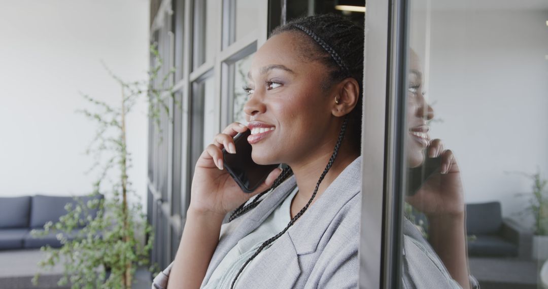 Professional Woman Smiling While Conversing on Smart Phone