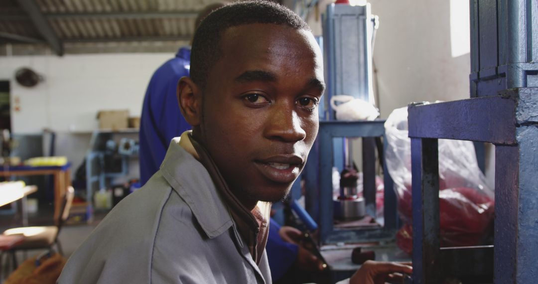 Young African Man Working in Industrial Workshop - Free Images, Stock Photos and Pictures on Pikwizard.com