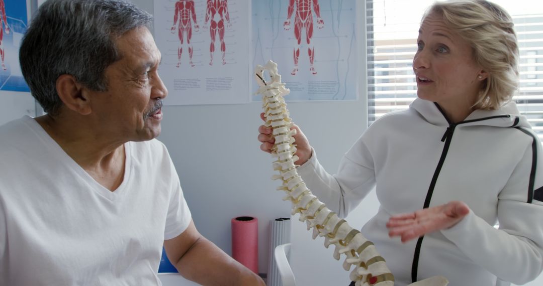 Doctor Explaining Human Spine to a Patient in a Clinical Setting - Free Images, Stock Photos and Pictures on Pikwizard.com