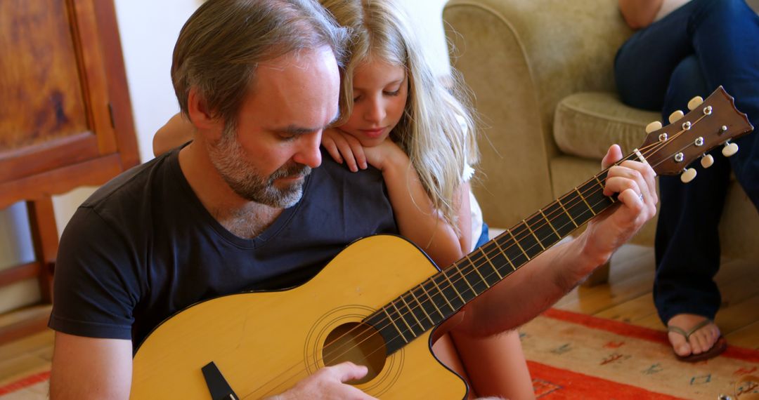 Father teaching daughter to play acoustic guitar at home - Free Images, Stock Photos and Pictures on Pikwizard.com