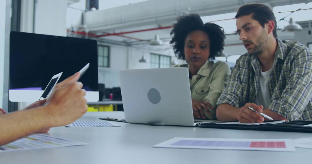 Diverse Team Collaborating Over Digital Concepts in Modern Office
