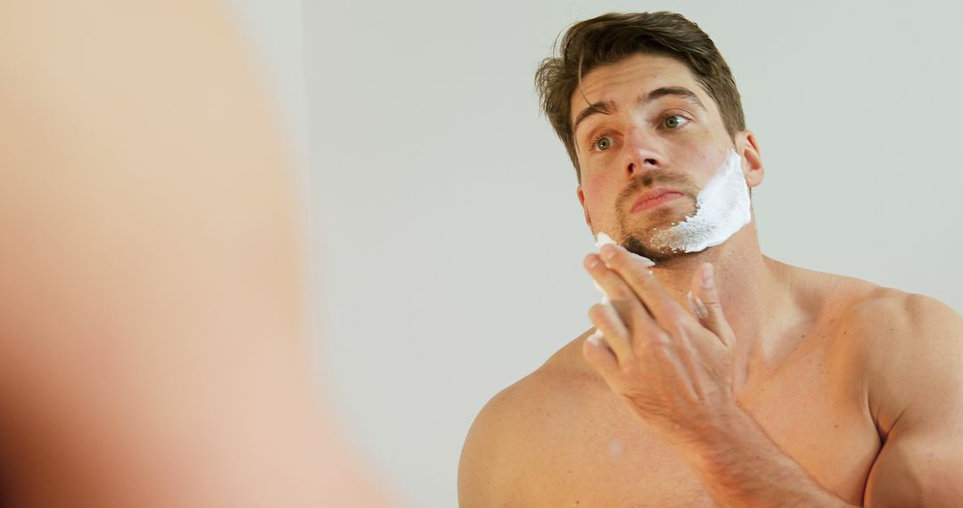 Young Man Applying Shaving Cream to Face in Bathroom Mirror - Free Images, Stock Photos and Pictures on Pikwizard.com