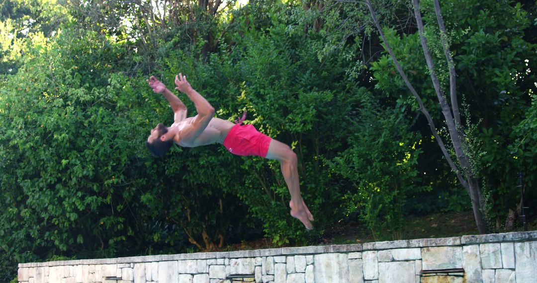 Athletic Man Jumping Backflip at Poolside on Sunny Day - Free Images, Stock Photos and Pictures on Pikwizard.com