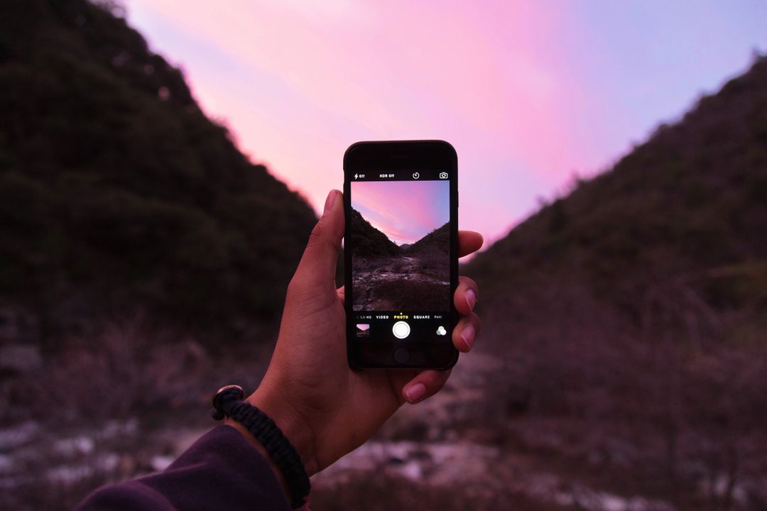 Hand Holding Smartphone Taking Picture of Sunset Over Mountains - Free Images, Stock Photos and Pictures on Pikwizard.com