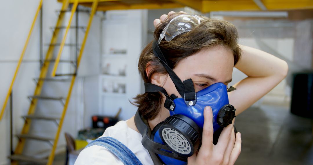 Young Woman Wearing Face Mask in Industrial Workspace - Free Images, Stock Photos and Pictures on Pikwizard.com