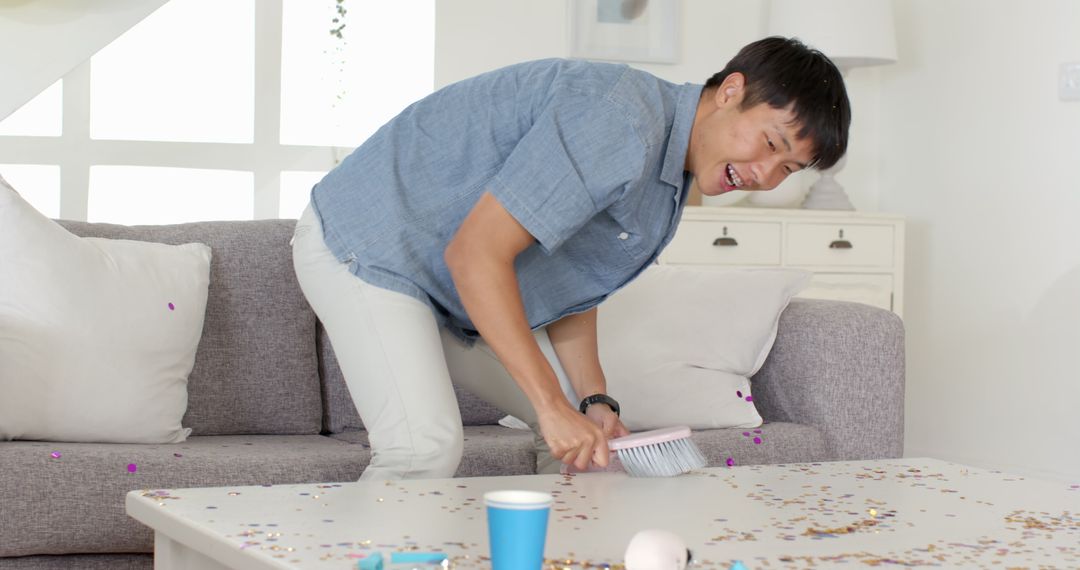 Man Tidying Living Room After Party