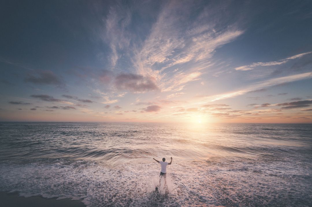 Person Enjoying Ocean Waves and Sunset