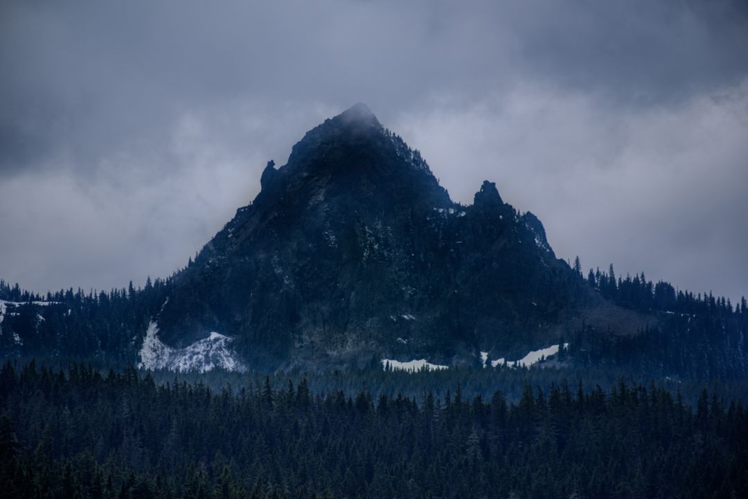 Dramatic Cloudy Mountain Peak with Snow in Foreboding Sky - Free Images, Stock Photos and Pictures on Pikwizard.com