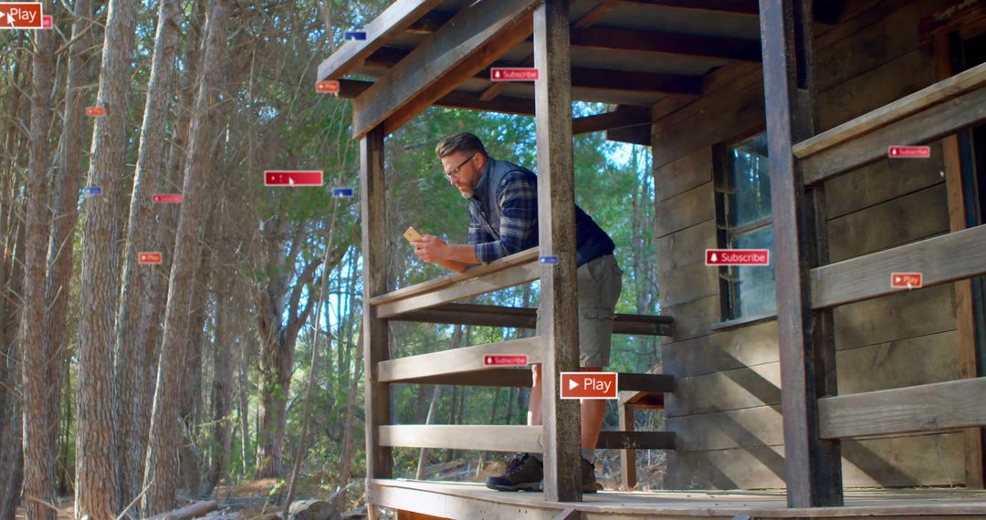 Man Engaging with Smartphone on Cabin Porch in Wilderness