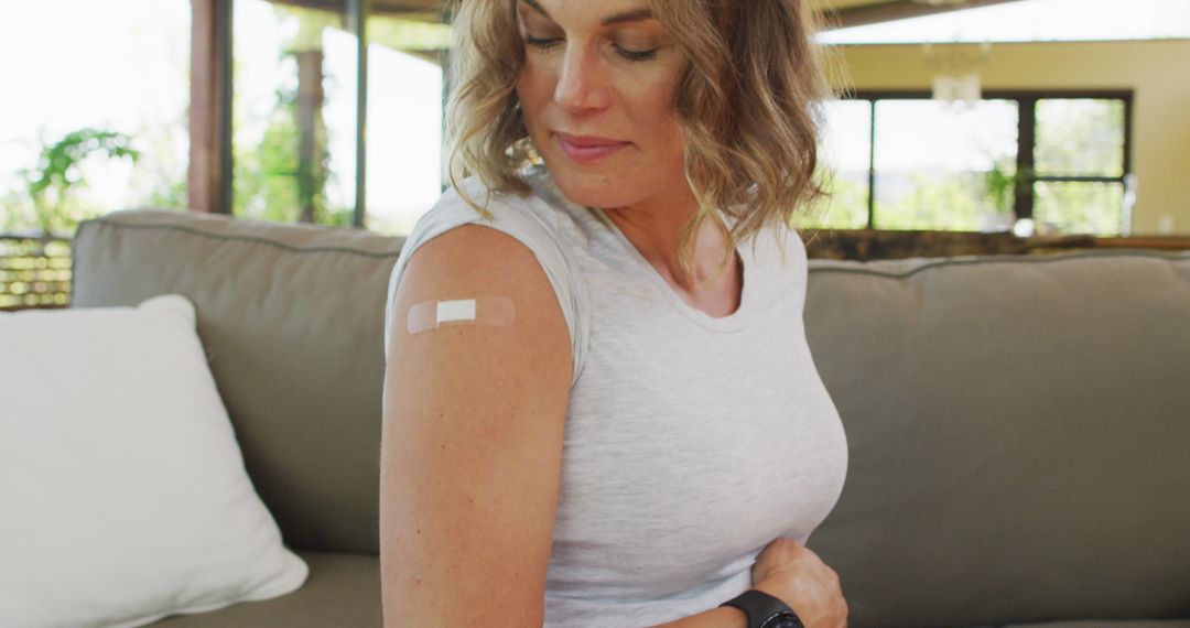 Pregnant Woman Proudly Displaying Arm Post-Vaccination at Home