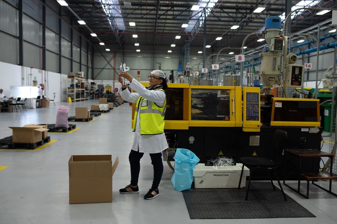 Caucasian Female Worker Inspecting Plastic Part in Factory Warehouse - Free Images, Stock Photos and Pictures on Pikwizard.com