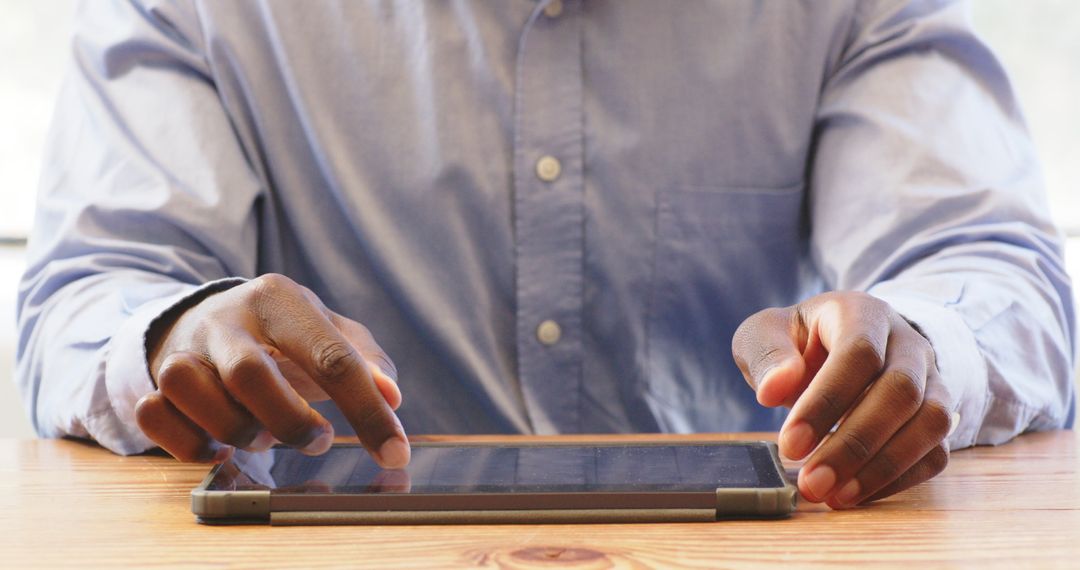 Professional Man Using Tablet for Business Tasks at Office Desk