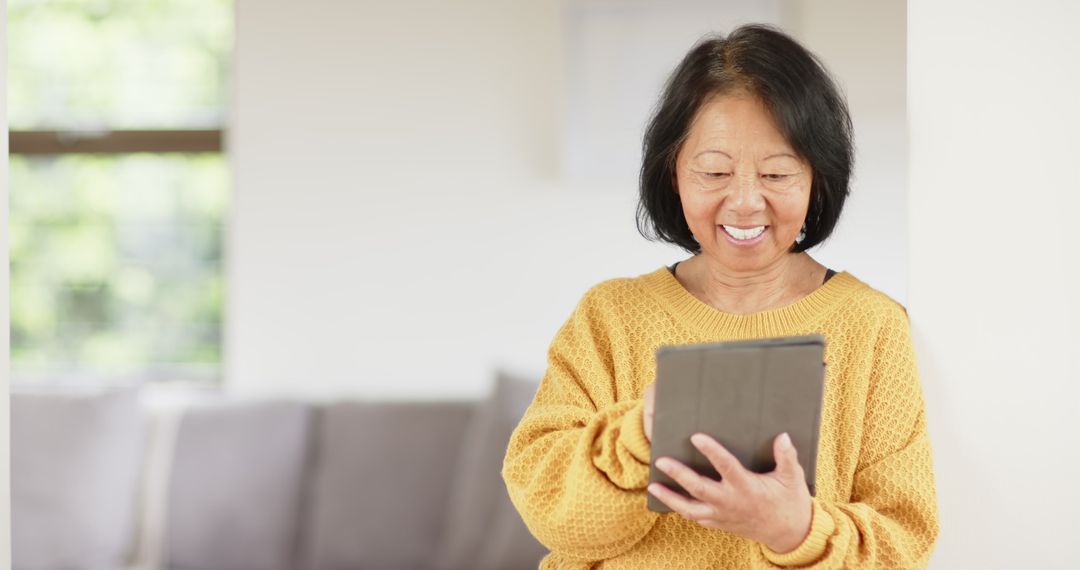 Senior Chinese Woman Enjoying Tablet at Home