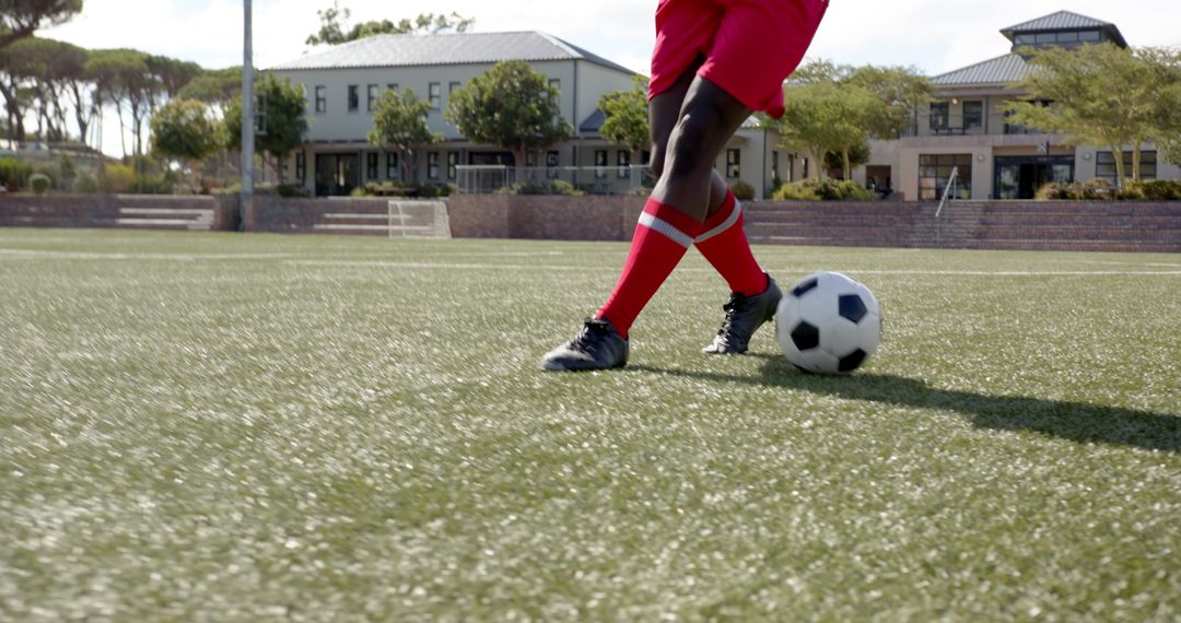 Soccer Player in Red Uniform Controlling Ball on Turf Field