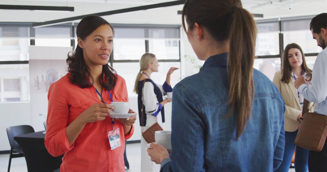 Women Engaging in Collaborative Discussion at Office Networking Event