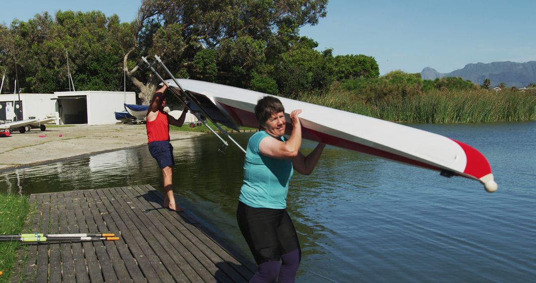 Senior Women Carrying Canoe on Dock with Row Team - Free Images, Stock Photos and Pictures on Pikwizard.com