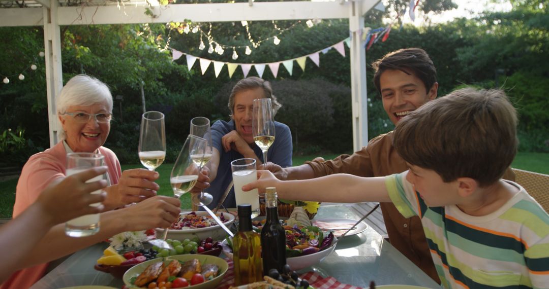 Multi-generational Family Toasting During Outdoor Garden Meal - Free Images, Stock Photos and Pictures on Pikwizard.com