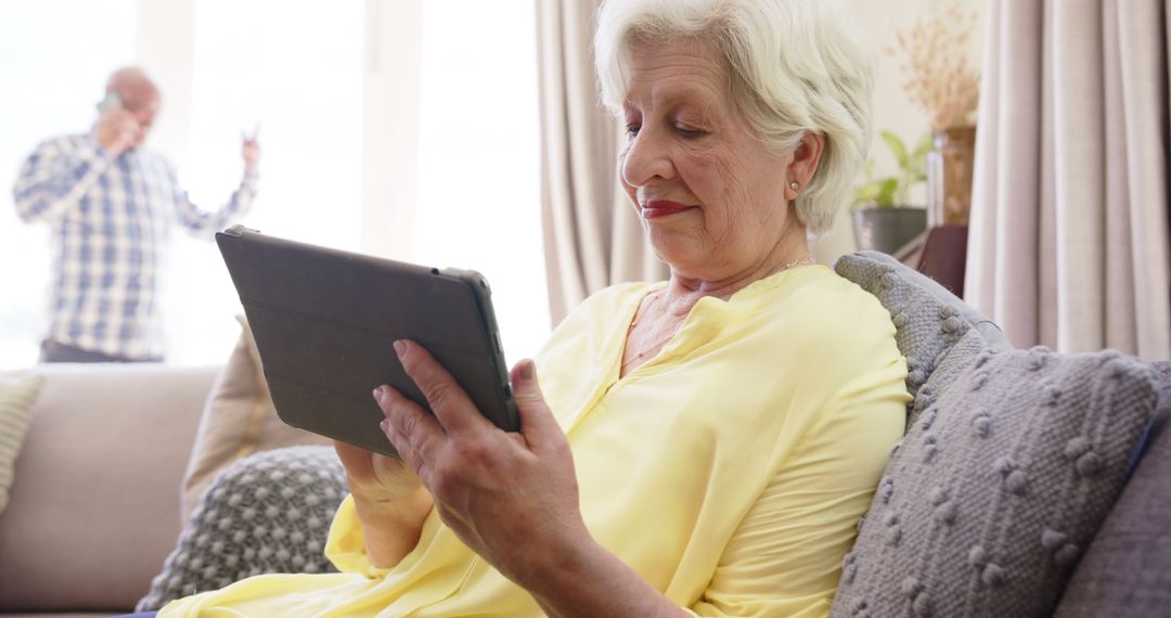 Senior Woman Using Tablet On Sofa At Home - Free Images, Stock Photos and Pictures on Pikwizard.com