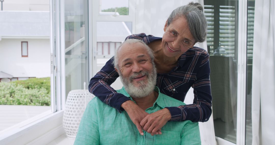 Smiling Elderly Couple Embracing Indoors - Free Images, Stock Photos and Pictures on Pikwizard.com