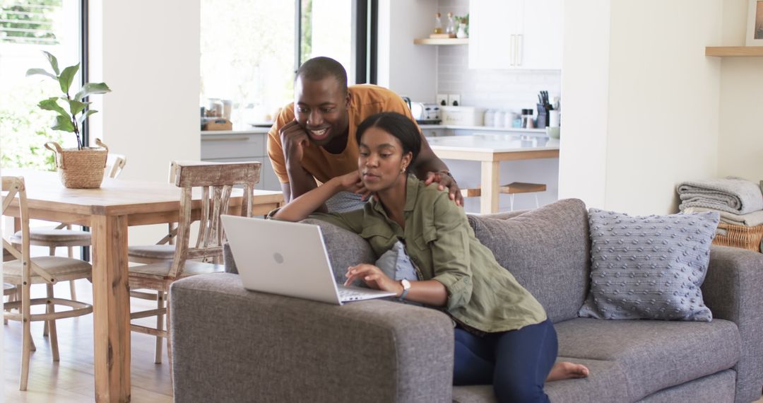 Couple Relaxing at Home Discussing Online Content on Laptop