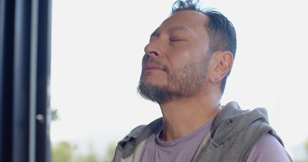 Man Practicing Meditation Near Window in Peaceful Light