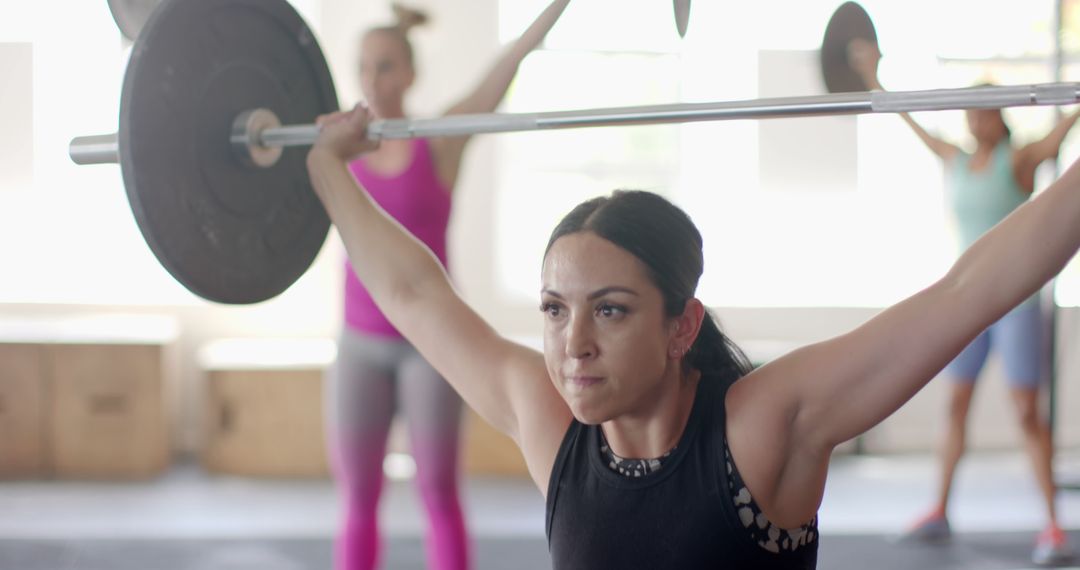 Focused Woman Lifting Barbell during Workout in Gym - Free Images, Stock Photos and Pictures on Pikwizard.com