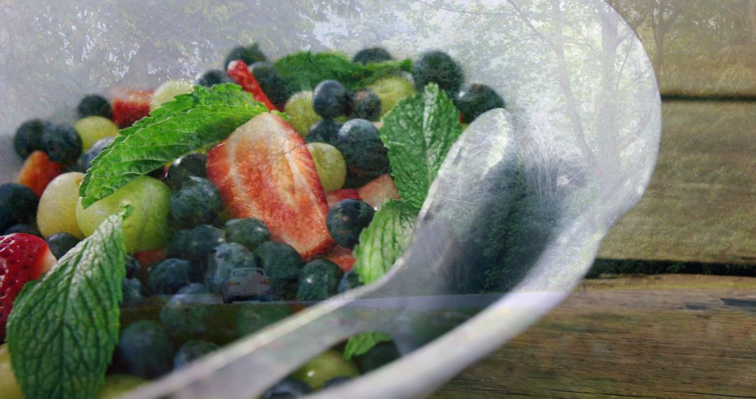 Fresh Berries and Mint in White Bowl on Rustic Table