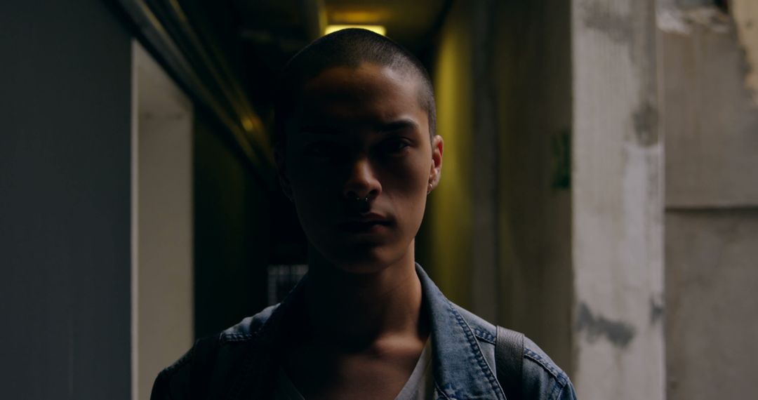 Moody Portrait of Person with Buzz Cut in Dimly Lit Corridor - Free Images, Stock Photos and Pictures on Pikwizard.com