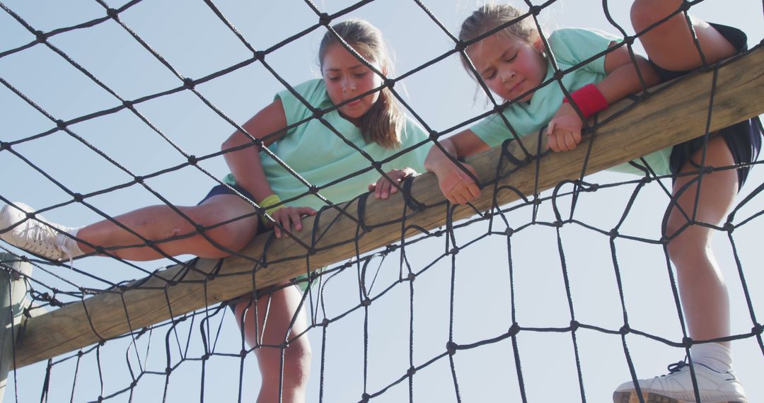 Two Girls Climbing Rope Net in Outdoor Adventure Park - Free Images, Stock Photos and Pictures on Pikwizard.com