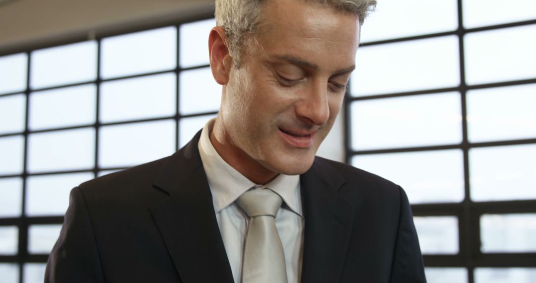 A middle-aged Caucasian businessman in a suit looks down thoughtfully, with copy space - Free Images, Stock Photos and Pictures on Pikwizard.com