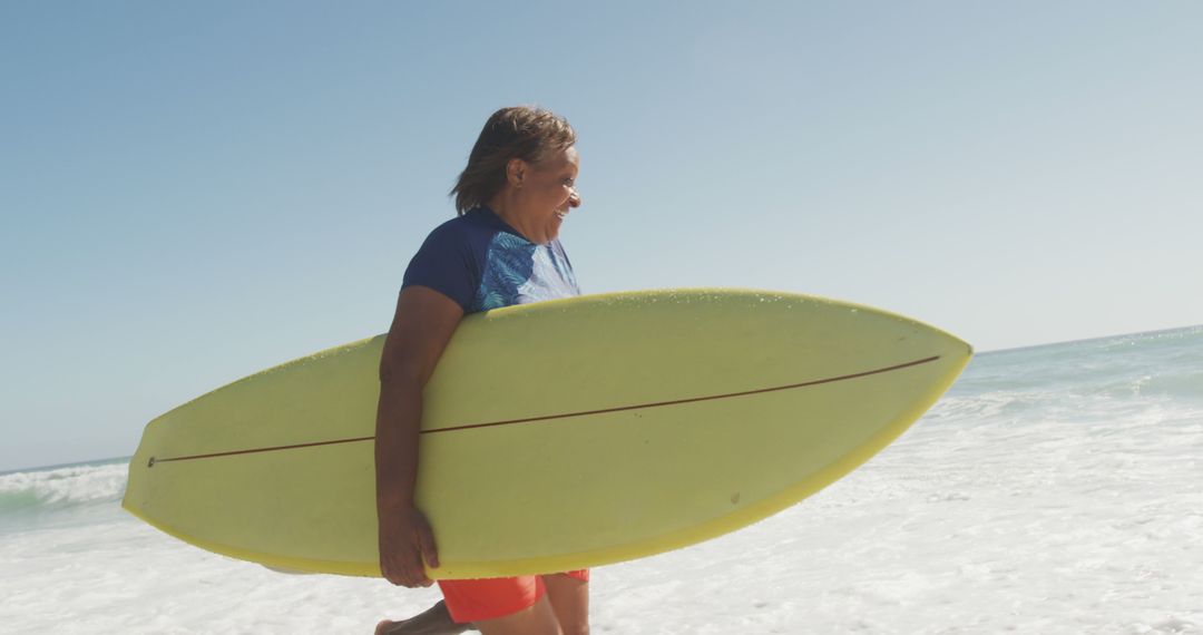 Smiling Senior Surfer Holding Yellow Surfboard on Beach - Free Images, Stock Photos and Pictures on Pikwizard.com