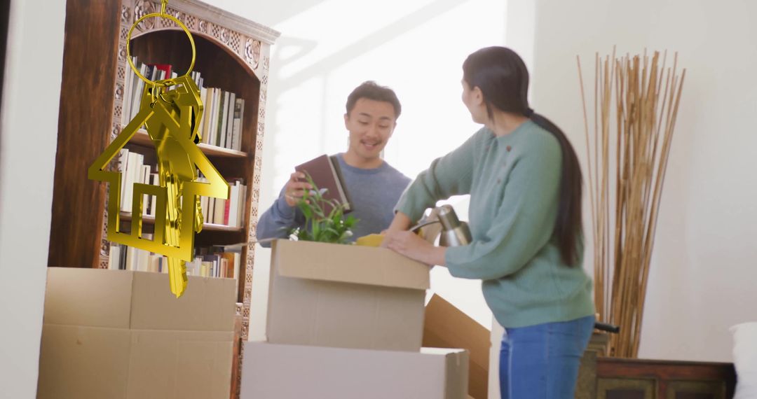 Happy Couple Unpacking Boxes in New Home with Gold House Key