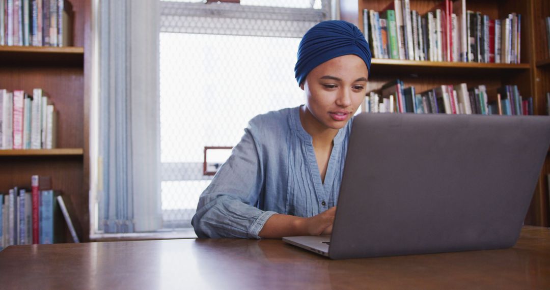 Young Woman Studying on Laptop in Library - Free Images, Stock Photos and Pictures on Pikwizard.com