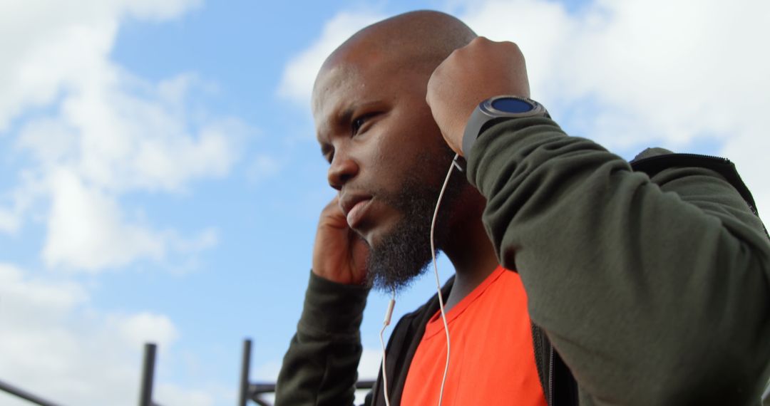 Man Listening to Music in Park with Smart Watch