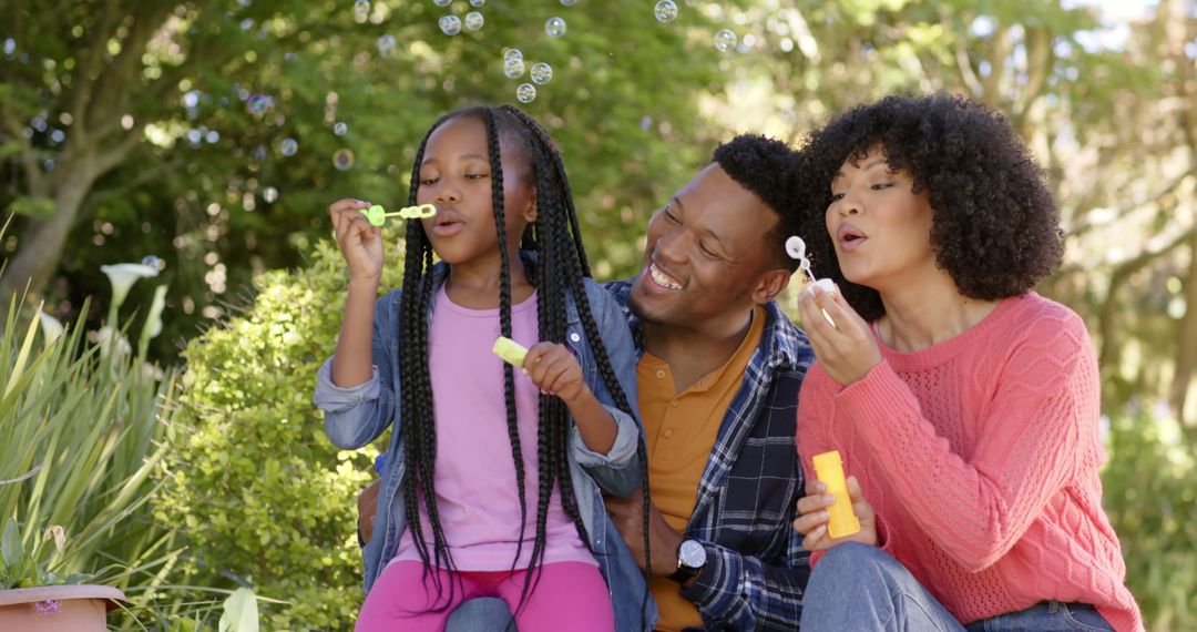 Happy African American Family Blowing Bubbles in Sunny Garden - Free Images, Stock Photos and Pictures on Pikwizard.com