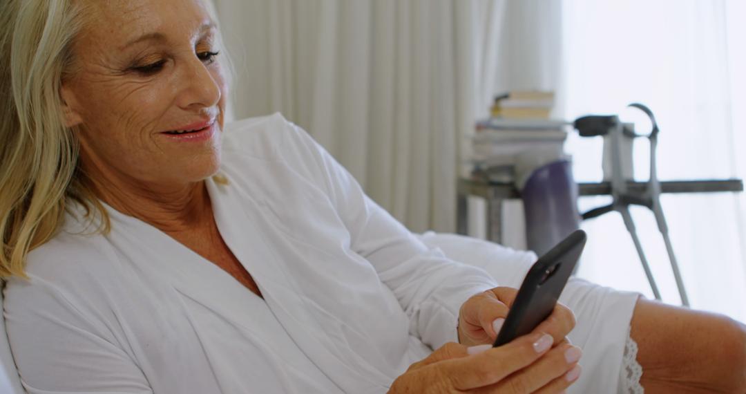 Senior Woman Relaxing in Bed Using Smartphone - Free Images, Stock Photos and Pictures on Pikwizard.com