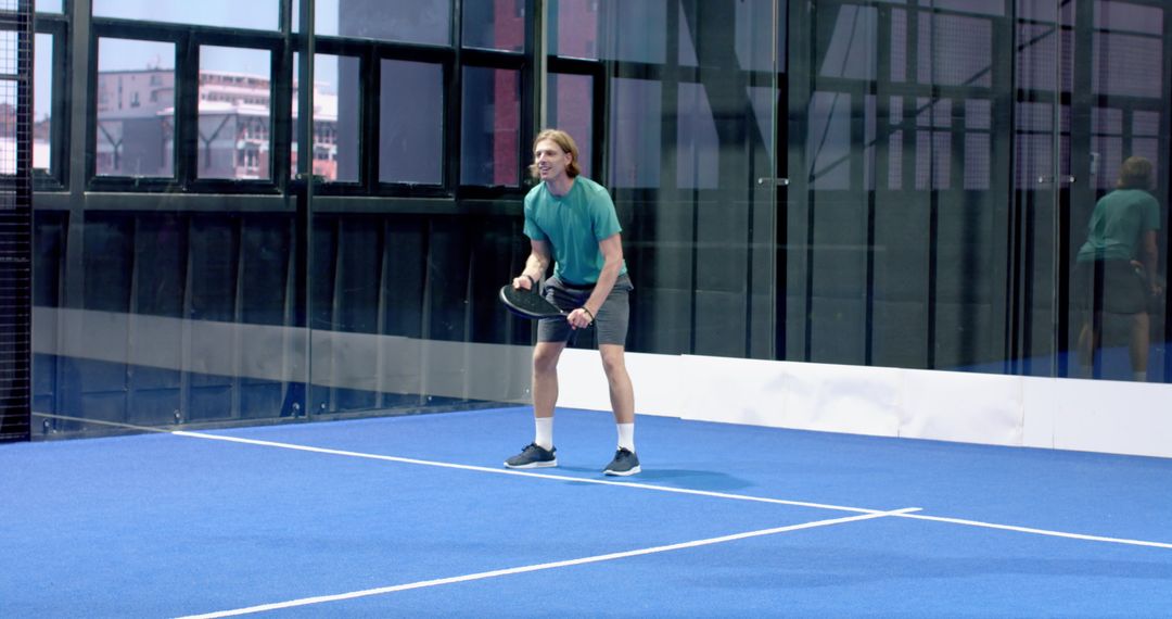 Man Practicing Padel Shots on Blue Indoor Court
