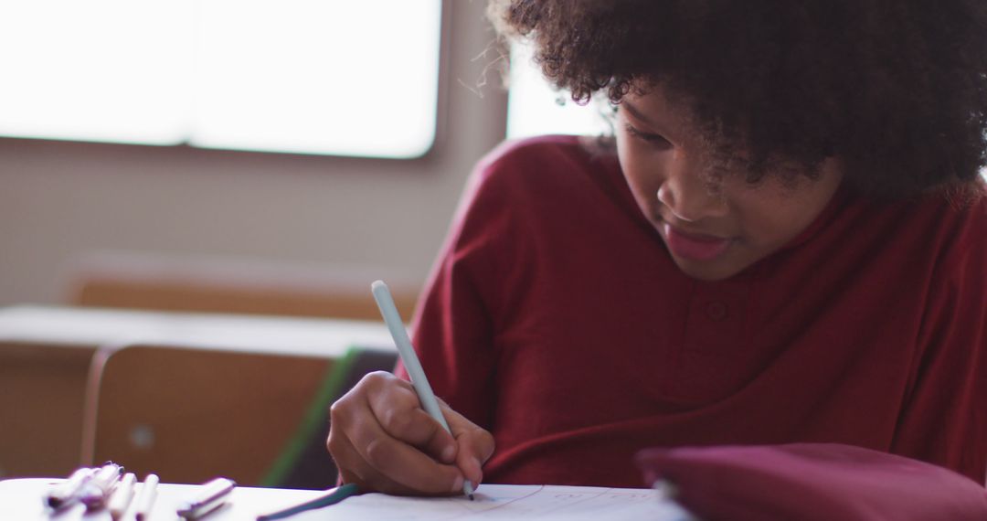 Joyful Biracial Student Writing in Classroom Setting